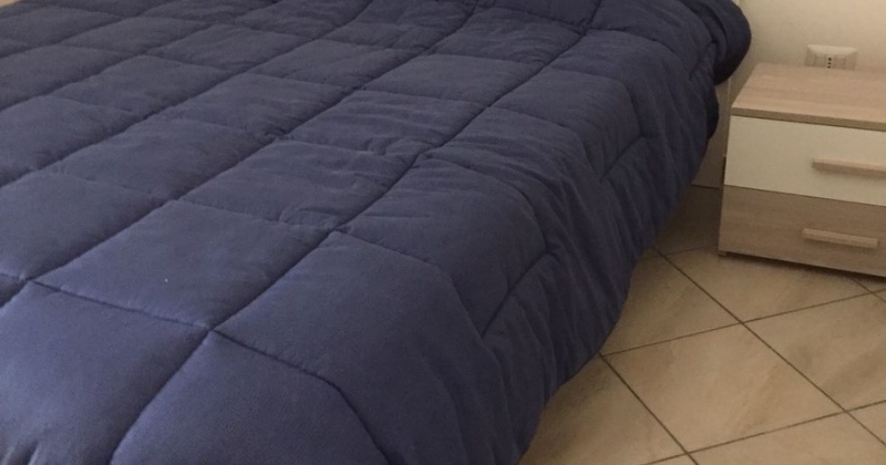 nella foto vediamo un letto con comodini di una villa in Pescoluse una marina del salento in puglia